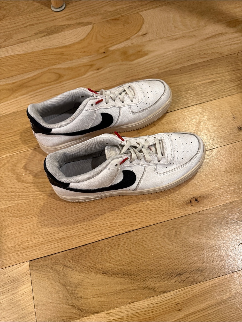Nike Kids White Sneakers with Black Swoosh and Red Accents